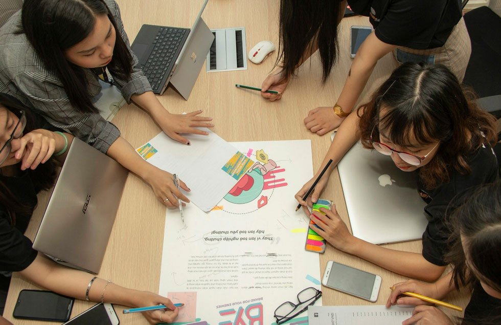 A leader facilitating a team discussion in front of a wall of planning notes